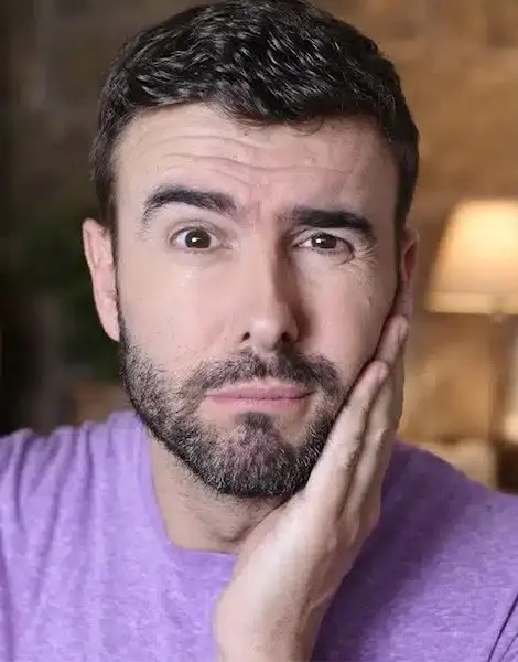 Man with beard touching his face, considering dental treatment options.