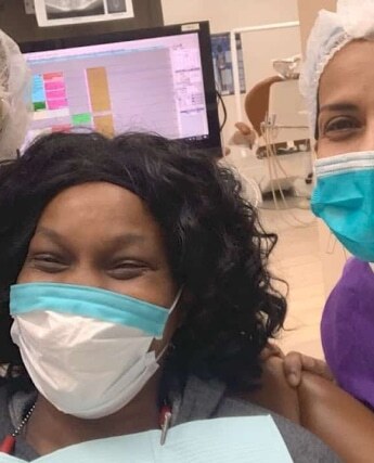 Two dental patients wearing masks smile together at a Plantation, Florida dental practice.