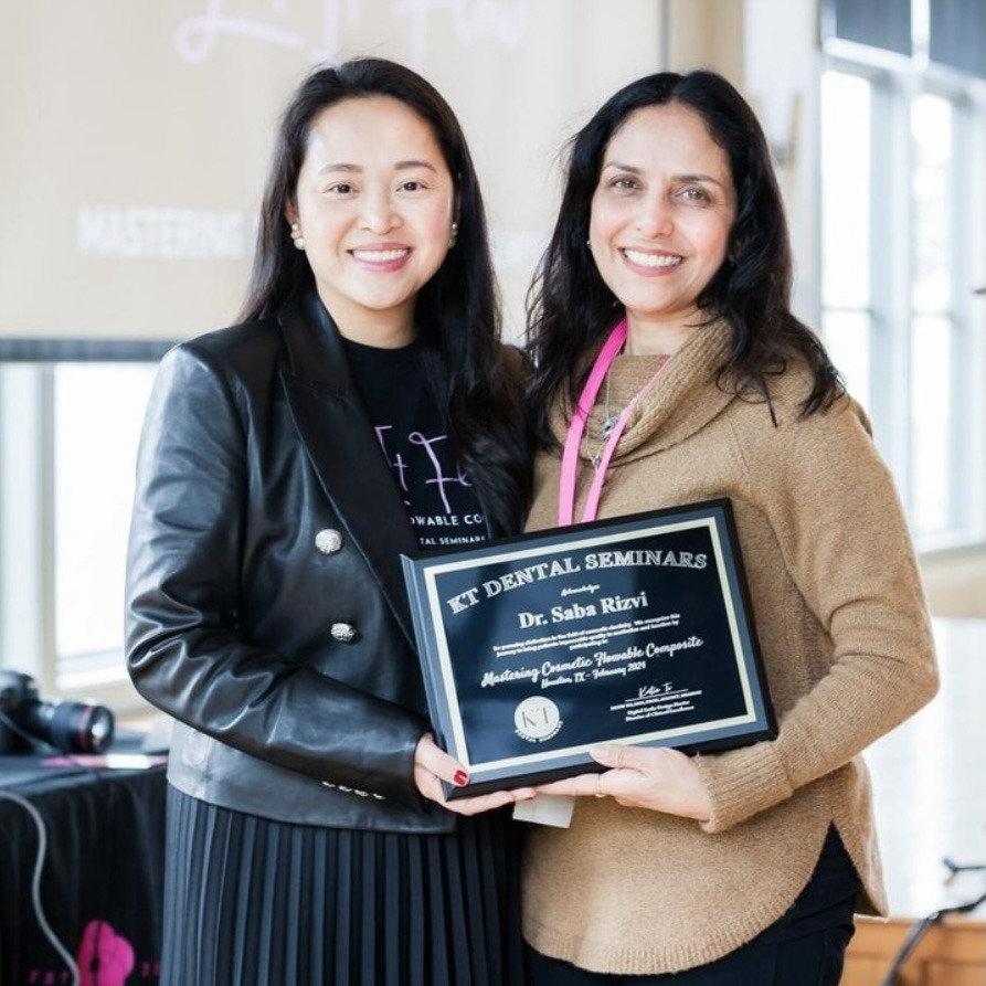 Two women smiling while holding a dental seminar certificate for composite fillings.