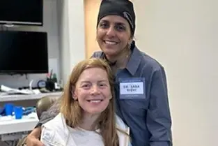 Two dental professionals smiling together in a clinical setting in Plantation, Florida.