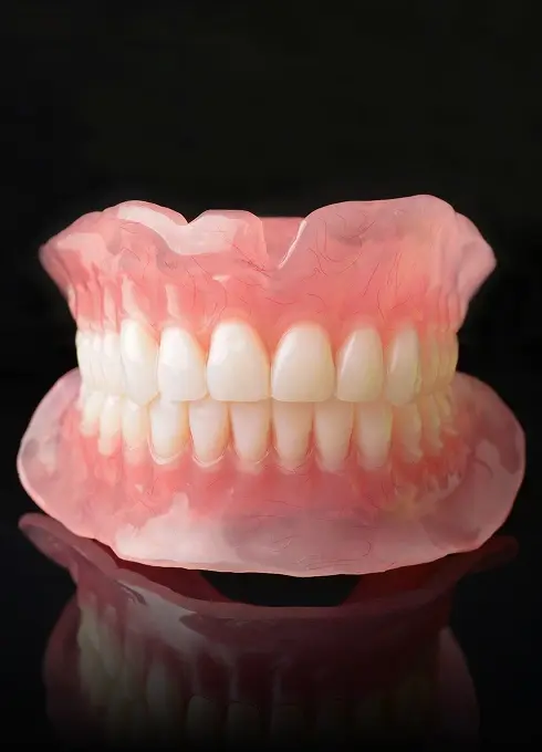 Full denture model displaying complete upper and lower artificial teeth against a black background.