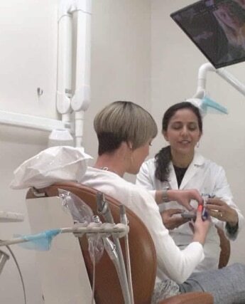 Dentist consulting with patient in dental treatment room at Plantation, FL practice.