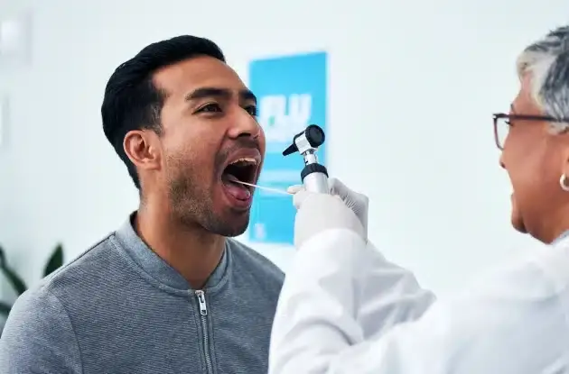Dentist examining patient's mouth during oral cancer screening in Plantation, FL.