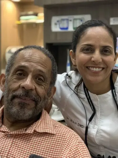 Smiling female dentist with male patient in dental office in Plantation, FL.