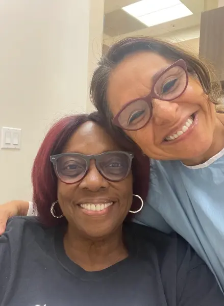 Two smiling women wearing glasses at a dental practice in Plantation, FL.