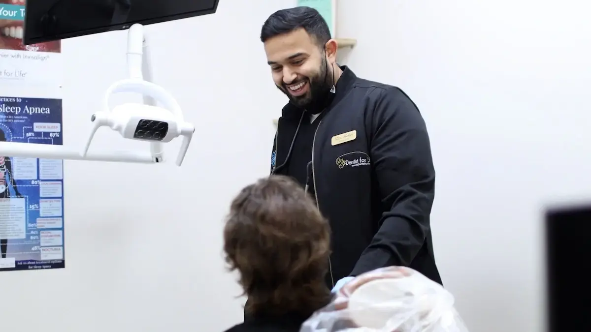Smiling dentist discussing root canal treatment with patient in Plantation dental office.