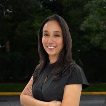 Saira, dental team member at Plantation, FL practice, smiling professionally outdoors.