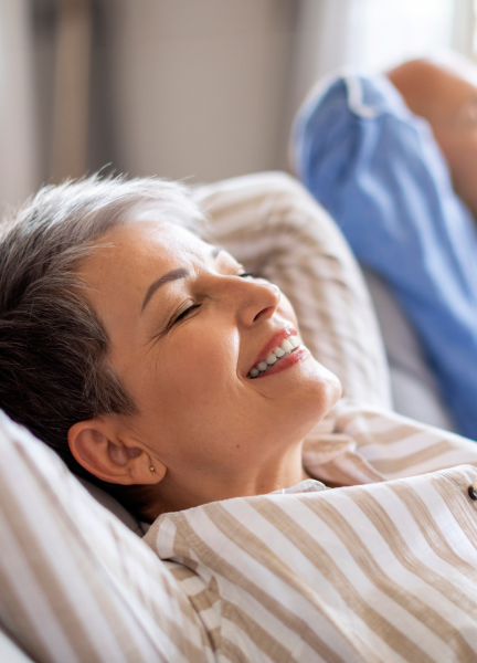 Relaxed patient smiling while resting on pillows during a sleep study test in Plantation, FL.